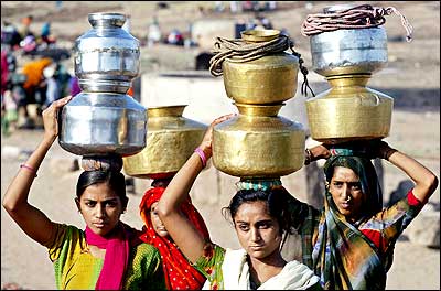 Women carry pitchers filled with drinking water