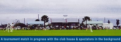 A tournament match in progress with the club house and spectators in the background