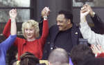 US civil rights campaigner, the Reverend Jesse Jackson (R), holds hands with former Enron employees during a rally