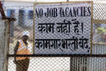 A security guard stands next to a gate of the Dabhol power plant. Reuters file photo/Arko Datta