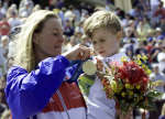 Brigitte McMahon of Switzerland holds her son Dominic after receiving her gold medal. REUTERS/Mark Baker 