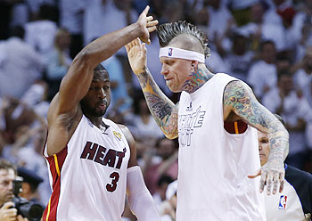 Miami Heat's Dwyane Wade (left) and Chris Andersen celebrate after the Heat defeated the San Antonio Spurs in overtime in Game 6 of their NBA Finals basketball playoff in Miami, Florida on Tuesday
