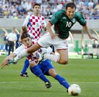 Croatia's Boris Zivkovic brings down Mexico's Cuauhtemoc Blanco. 