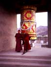 A prayer wheel and two young monks